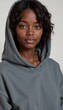 © Natalia - Stylish young woman with curly hair wearing a gray hoodie, looking confidently at the camera