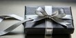 © Watcharapon - Black and silver ribbon tied around a silver gift package , gift, present, box, ribbon, wrapping, silver