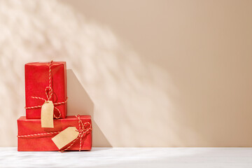 Aufkleber - Christmas template featuring gift boxes on a table with shadows and sun glares softly falling on the wall