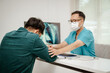© tong2530 - A doctor comforting lung cancer patient with an infographic of lungs in the background.
