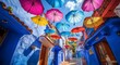 © tolem929 - A vibrant street with blue buildings and colorful umbrellas hanging above.