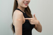 © Pormezz - Happy woman showing bandage on her arm after received vaccine isolated on background.