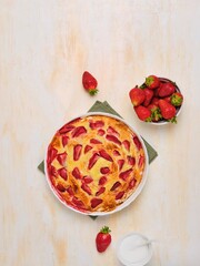 Wall Mural - Step by step cooking of filo pastry pie with cream and strawberries on light concrete background.