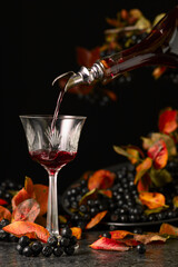 Poster - Black chokeberry liqueur is poured from a bottle into a glass.