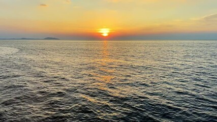 Wall Mural - Bright red orange colors on ocean water in Thailand.Sunset sky over the sea in Thailand