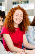 © Xavier Lorenzo - Vertical shot of young female student smiling at camera while studying in group at high school. Education concept