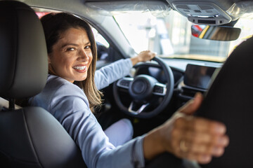 happy young woman testing new car before buying in showroom salon, concept buy first vehicle.. test 