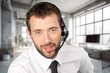 © BillionPhotos.com - Happy call center worker wearing headset working in support office.