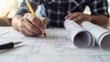 © Sirichat. Camphol - An engineer using blueprints and technical drawings to plan the construction of a large-scale infrastructure project