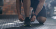 © peopleimages.com - Hands, fitness and tie shoes in gym for workout, training or exercise start for health. Sports, athlete wellness and man tying sneakers, footwear and laces to get ready for cardio and performance