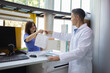 © Westend61 - Pharmacist giving shopping bag to happy customer at desk