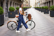 © Westend61 - Fashionable mid adult woman with electric bicycle crossing street