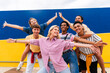 © Westend61 - Group of young friends with colorful clothing posing happily in front of wall