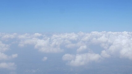 Wall Mural - Aerial view above the clouds and sky inspiration concept in cinematic breathtaking aerial flying over white fluffy cloudscape in high altitude sky with fresh clean air and blue skies on background.