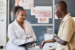 © Seventyfour - Side view portrait of smiling female doctor holding clipboard while consulting patient complaining of skin rash and allergies