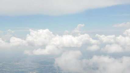 Wall Mural - view from plane over blue sky with white Fluffy clouds while flying through in sunny summer time.nature blue sky cloud and sun for Clean Environment, save energy or transportation holiday concept. 