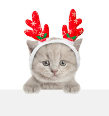 Aufkleber - Cute tiny kitten dressed like santa claus reindeer  Rudolf looking above empty white banner. isolated on white background