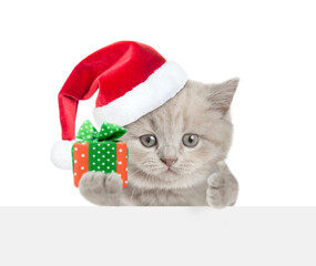 Poster - Cute tiny cat holding gift box above blank white banner and showing thumbs up gesture. isolated on white background