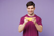 © ViDi Studio - Young gambling man he wear violet t-shirt casual clothes use play racing app on mobile cell phone hold gadget smartphone for pc video games isolated on plain light purple background Lifestyle concept