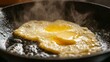 © Winarsih - Two Fried Eggs Cooking in a Black Pan with Steam Rising