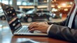 © MahmudulHassan - Close up of businessman working on laptop in car showroom