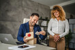 © Miljan Živković - Female colleague surprise with gift her male colleague in the office