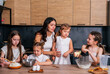 © dvulikaia - A young mother cooks cheeseecake  pie with her daughters. Mom teaches her daughters to cook.