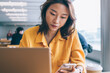 © BullRun - Woman using smartphone in workspace