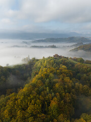 Wall Mural - aerial landscape with fluffy morning mists over the picturesque, autumn-covered rolling hills near m