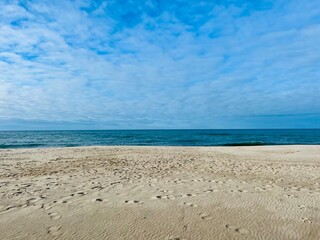 Wall Mural - Blue sea horizon, blue sky with white clouds, sandy seashore, wild empty beach