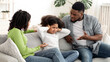 © Prostock-studio - Annoyed Black Parents Scolding Stubborn Little Daughter At Home, Girl Covering Ears With Hands