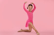 © New Africa - Little ballerina practicing dance moves on pink background