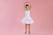 © New Africa - Little ballerina practicing dance moves on pink background