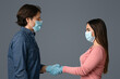 © Prostock-studio - Handshake Of Young Man And Woman In Protective Medical Face Masks And Gloves, Couple Shaking Hands Over Light Background, Copy Space
