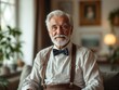 © Jeannette - An elderly man with white hair and a neatly groomed beard sits in a warmly lit living room, wearing a bow tie and suspenders