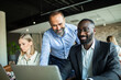 © Marko Geber - Business team collaborating on project in modern office environment