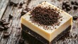 © fivan - Coffee-infused handmade soap with coffee grounds sprinkled on top, isolated on a rustic wooden background