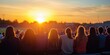 © Georgina B - Group of high school students watching a football game at sunset