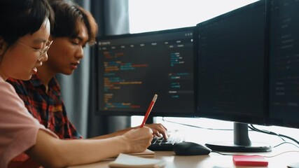 Slow motion back end software developer engineer for computer programming working together on debugging writing computing code, solving complex algorithms display on monitor in office. Burgeoning