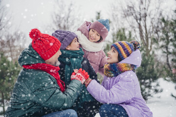 Poster - Photo of cheerful positive little child wife husband dressed coats holding hands arms together outdoors urban forest park