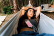 © Eloisa Ramos/Stocksy - Resting in Hammock with Smartphone on Chest