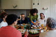 © BONNINSTUDIO/Stocksy - Happy family having dinner together at home for christmas time