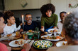 © BONNINSTUDIO/Stocksy - Happy family enjoying christmas dinner together at home