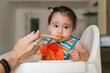 © Ezequiel Giménez/Stocksy - Baby Focused on Spoonful of Food at Home