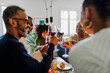© BONNINSTUDIO/Stocksy - Happy family is toasting while having lunch together at home