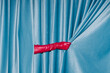 © Ulas&Merve/Stocksy - Red Gloved Hand Opening Blue Velvet Curtain
