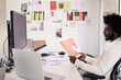 © Guille Faingold/Stocksy - Designer Evaluating Graphic Print. Black businessman reviewing p