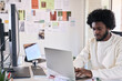 © Guille Faingold/Stocksy - Creative designer sitting at the desk of his creative studio typ