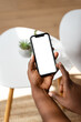 © mahalo studio/Stocksy - Man browsing smartphone with white isolated screen at home