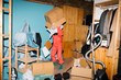 © Ulas&Merve/Stocksy - Person in Protective Suit Organizing Cluttered Storage Room